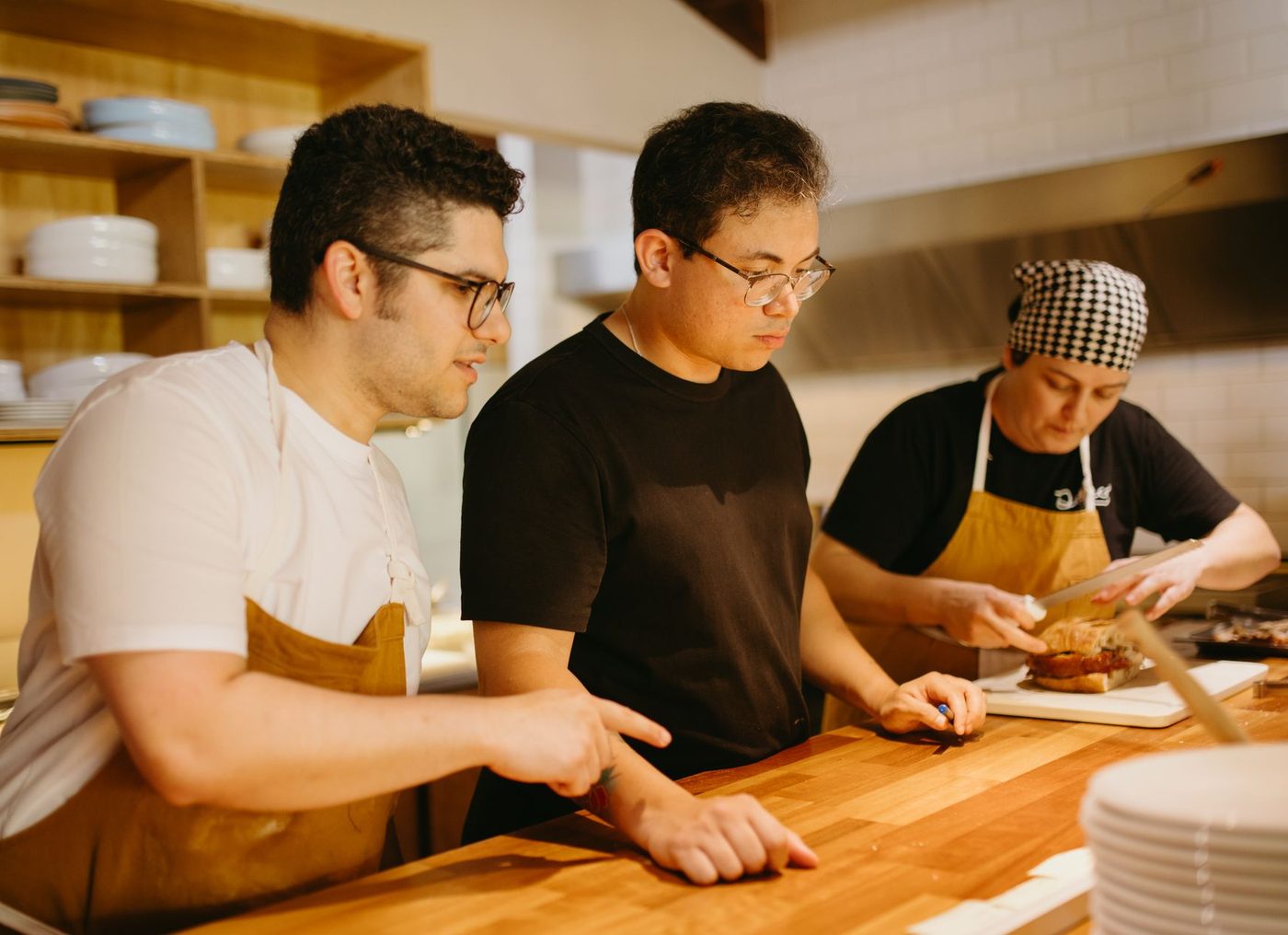 Restaurant kitchen team reviewing dishes before service